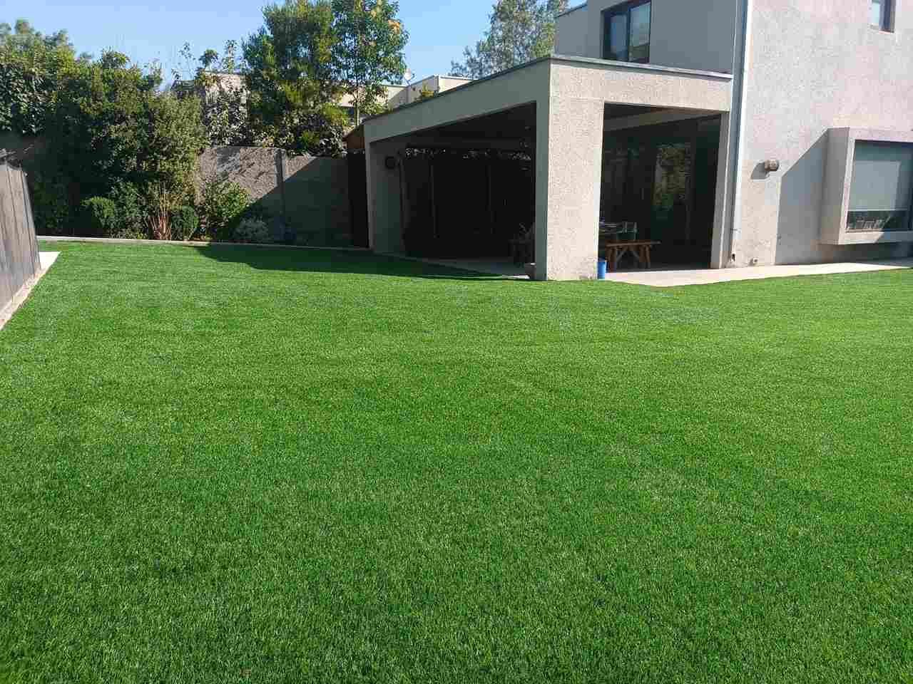 Instalación de pasto sintético en jardín residencial